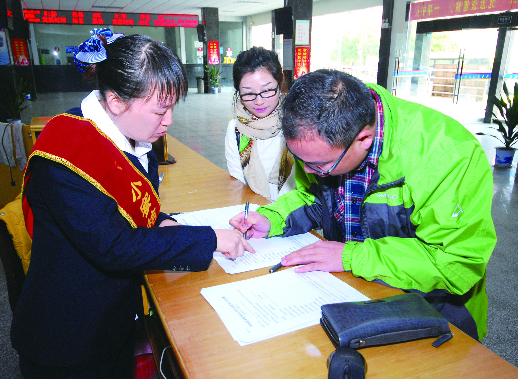 圖為洞口汽車總站站務人員在熱心為旅客服務。